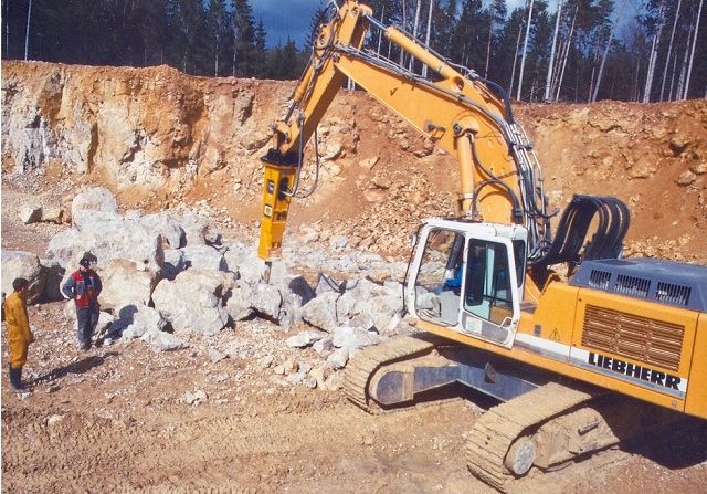 Hydraulikhammer an Baggerausleger beim Felsabbruch im Steinbruch – Anbaugerät für Abbruch und Gewinnung